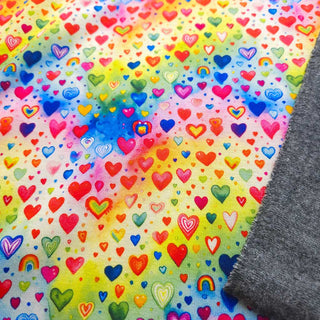 Alpenfleece Stoff – Herzchen auf Regenbogen