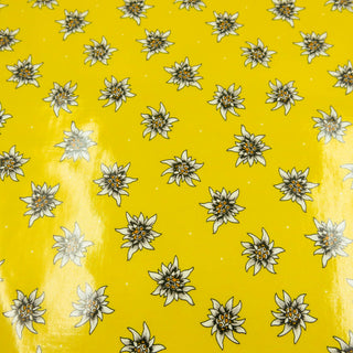 Wachstuch Stoff in Gelb mit Edelweiß-Muster – wasserabweisende, abwischbare Meterware für Tischdecken, Taschen & Deko – erhältlich bei Stoffrestposten.ch