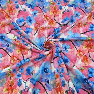 Digital bedruckter Baumwolljersey mit floralen Motiven in kräftigem Blau, Rosa und Rot – elastischer Stoff für Nähprojekte, erhältlich bei Stoffrestposten.