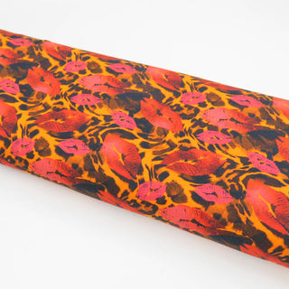 Jersey Stoff mit Leopardenmuster und Kussmund-Print in Pink und Rot – elastischer Baumwolljersey für auffällige Kleidung und kreative Nähprojekte, erhältlich bei Stoffrestposten.
