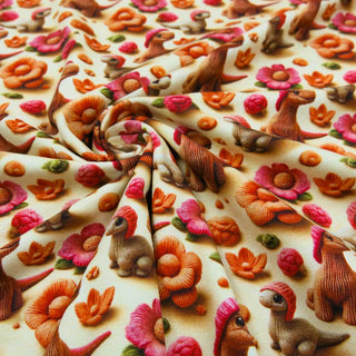 Jersey Stoff 3D Digitaldruck – gestrickte Dinosaurier mit bunten Blumen in Orange, Pink und Grün, ideal für Kinderkleidung von Stoffrestposten