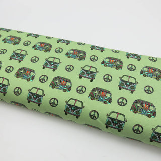 Weicher Jersey Stoff mit farbenfrohem Hippie-Bus-Motiv und Peace-Zeichen auf mintgrünem Hintergrund – elastischer Baumwolljersey für Kleidung und Accessoires, verfügbar bei Stoffrestposten.