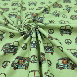 Weicher Jersey Stoff mit farbenfrohem Hippie-Bus-Motiv und Peace-Zeichen auf mintgrünem Hintergrund – elastischer Baumwolljersey für Kleidung und Accessoires, verfügbar bei Stoffrestposten.